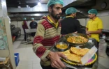 Un serveur transporte des plats pakistanais dans la cuisine du restaurant Chattha's, l'un des plus réputés d'Islamabad, le 18 janvier 2019
