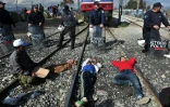 Des migrants sont allongés sur des rails de chemin de fer près du village grec de Idomeni, le 3 mars 2016 pour dénoncer la fermeture des frontières