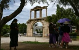 Des touristes s'abritent à l'ombre, à Athènes, le 13 juin 2024