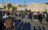Les forces de sécurité israéliennes tiennent des Palestiniens à l'écart devant la porte de Damas, dans la vieille ville de Jérusalem, rassemblés pour observer une manifestaton de nationalistes israéliens se dirigeant vers la place Tzahal, le 20 avril 2022.