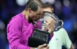 L'Espagnol Rafaël Nadal embrasse son trophée après battu le Russe Daniil Medvedev en finale de l'Open d'Australie, le 31 janvier 2022 à Melbourne