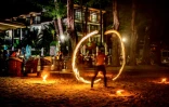 Jongleur de feu devant quelques touristes sur l'île thaïlandaise de Phuket le 30 octobre 2021