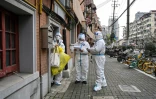 Des agents des services de santé chinois dans une rue de Shanghai le 26 mars 2022