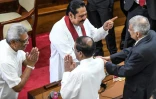 Le nouveau Premier ministre du Sri Lanka Mahinda Rajapaksa (2e à g.) et son frère, le président Gotabaya Rajapaksa (à g.) échangent avec Ranil Wickremesinghe (à d.) lors de l'investiture du chef du gouvernement à Colombo, le 21 novembre 2019