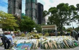Des personnes déposent des fleurs et rendent hommage aux victimes de l'incendie meurtrier de Wang Fuk Court, le 1er décembre 2025 à Hong Kong