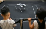 Des enfants regardent un robot télécommandé de Unitree lors d’une visite du Centre d’expérience de l’intelligence incarnée de Unitree Robotics, dans le district de Jing’an à Shanghai, le 19 août 2026