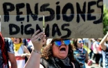 Une femme tient une pancarte réclamant "des retraites dignes" devant le palais présidentiel de La Moneda à Santiago le 30 octobre 2019