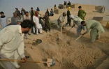 Proches et amis recouvrent de terre la tombe d'une victime de l'attentat suicide d'hier lors des funérailles dans un cimetière de Kunduz le 9 octobre 2021