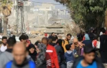 Un véhicule blindé israëlien passe devant des habitants fuyant les combats dans la bande de Gaza sur la route de Salaheddine dans le district de Zeitoun, dans le sud de la bande de Gaza, le 19 novembre 2023