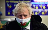 Le Premier ministre Boris Johnson arborant un masque du drapeau gallois le 3 mai 2021 sur l'île de Barry, au Pays de Galles