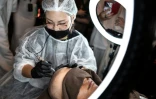 Un tatoueur spécialisé dans le tatouage du cuir chevelu lors d'un concours à Naha, dans la préfecture d'Okinawa, le 8 juillet 2026