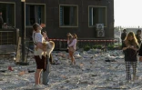 Des habitants se tiennent à l'extérieur d'un immeuble d'habitation endommagé par des frappes de missiles et de drones russes sur la ville portuaire ukrainienne d'Odessa, le 12 septembre 2026  
