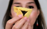 Une représentante de la communauté juive tien un biscuit hamantaschen lors de la célébration de Pourim à Tondano, en Indonésie, le 12 mars 2017
