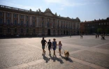 Une famille traverse la Place du Capitole Ă Toulouse sous le soleil, dans le sud-ouest de la France le 28 juillet 2024