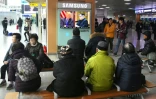 Des personnes regardent un téléviseur montrant des photographies du président américain Donald Trump (G) et du dirigeant nord-coréen Kim Jong Un dans une gare de Séoul, le 9 mars 2018