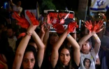Des Israéliennes aux mains couvertes de peinture rouge symbolisant le sang participent à une manifestation près de la résidence du Premier ministre Benjamin Netanyahu à Jérusalem, appelant à des élections anticipées et à la libération des otages détenus à Gaza, le 27 juin 2024
