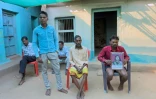 L'agriculteur Mohan Singh Gond (d), aux côtés de membres de sa famille, tient le portrait de sa défunte mère Lakshmibai Gond, piétinée et tuée en 2022 par des éléphants alors qu'elle surveillait ses champs, le 12 mars 2025 dans le district de Gariaband, dans l'Etat du Chhattisgarh, en Inde