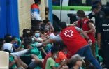 Des agents de la Croix Rouge viennent en aide à des migrants mineurs qui attendent de subir un test de Covid-19 à leur arrivée sur l'enclave espagnole de Ceuta le 19 mai 2021