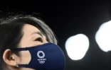 Une bénévole avec un masque sanitaire aux couleurs des Jeux olympiques de Tokyo 2020, dans le stade de la capitale du Japon le 22 juillet 2021