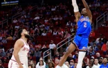 Shai Gilgeous-Alexander, le meneur canadien du Thunder d'Oklahoma City, tire devant Fred VanVleet, l'arrière des Rockets de Houston, pendant un match de NBA, à Houston, le 25 février 2024