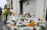 Des habitants déposent des gerbes de fleurs, le 11 juin  2019, devant le garage où un enfant a été tué et un autre gravement blessé par un chauffard à Lorient 