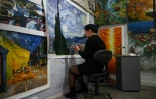 Une artiste peint une copie d'un tableau de Vincent Van Gogh dans un atelier du village de Dafen, le 19 février 2023 en Chine