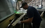 Un employé de l'entreprise Ugears découpe au laser les différentes parties d'une maquette en bois, le 6 juin 2022 à Gorenka, au nord de Kiev, en Ukraine 