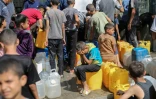 Des enfants palestiniens affluent à une distribution d'eau à Nousseirat, dans le centre de la bande de Gaza, le 4 septembre 2025