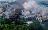 Une épaisse fumée s'élève dans le ciel à Dacca après l'incendie par des manifestants d'un musée, le 5 août 2024