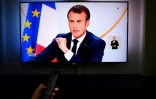 Un écran de télévision montrant le président français Emmanuel Macron lors de son allocution en direct à Paris, le 25 avril 2019