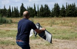 Un technicien de la startup RoboCare se prépare à faire voler un drone au-dessus d'un domaine agricole pour scanner les arbres et évaluer leur niveau d'hydratation ou la qualité du sol, le 30 août 2023 à Nabeul, au Maroc