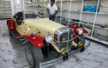 Le collectionneur Jaafar Salmane à côté d'une Mercedes Benz de 1932 restaurée, dans son magasin de pièces détachées à Alexandrie, dans la province de Babel, le 27 mai 2025 en Irak