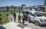 Des membres des forces de sécurité kurdes accompagnent des membre des familles de combattants du groupe Etat Islamique avant de les remettre à des diplomates néerlandais dans la ville syrienne de Qamichli (nord-est)