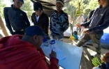 Un homme qui travaillait dans un service d'urgences au Venezuela donne des consultations médicales improvisées à ses compatriotes, dans un campement de fortune près d'une gare de bus, le 9 août 2018 à Quito, en Equateur