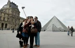 Des touristes devant le Louvre le 7 mars 2015 à Paris