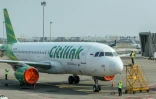 Des employés nettoient un Airbus A320 de la compagnie Citilink stationné sur le tarmac de l'aéroport Soekarno-Hatta, après la suspension des vols consécutive à l'éruption du volcan Anak Krakatau, le 7 septembre 2026 à Tangering, en Indonésie