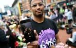 Un fan montre sur son téléphone portable une photo de lui et de l'auteur-compositeur-interprète britannique Ozzy Osbourne, devant mémorial improvisé sur le pont Black Sabbath, en hommage à l'artiste décédé, à Birmingham, dans le centre de l'Angleterre, le 23 juillet 2025