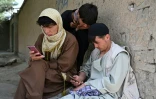 Des jeunes Afghans consultent leurs smartphones à Kaboul, le 10 août 2026