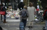 Une femme et un enfant se recueillent un moment en mémoire des victimes de la rue de Charonne, le 16 novembre 2015 à Paris