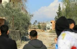 Des habitants observent un char de l'armée israélienne qui bloque l'entrée de Houla, dans le sud du pays, les empêchant de retourner dans leur village, le 27 janvier 2025