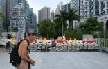 Un homme passe devant des sacs de sable destinés à retenir les eaux de crue, alors que le super typhon Ragasa approche de Hong Kong, le 23 septembre 2025