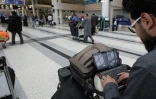 Un passager syrien devant son ordinateur portable avant de prendre son vol pour les Etats-Unis Ă Amman, le 22 mars 2017