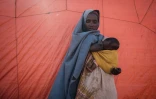 Une femme de 30 ans tient dans les bras son enfant d'un an dans le camp de déplacés de Muuri à Baidoa (Somalie), le 13 février 2022