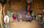 Aissetou Amadou, 52 ans, le 29 mai 2024 dans le camp de déplacés de Torodi avec l'un de ses enfants, à Dori, dans le nord-est du Burkina Faso