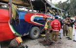 Des volontaires pakistanais et des forces de sécurité inspectent un bus détruit par une bombe qui a fait au moins 16 morts à Peshawar au Pakistan, le 16 mars 2016