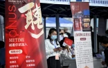Une femme tient un stand lors d'un salon de l'emploi, le 26 août 2022 à Pékin 