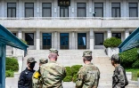 Le chef d'état-major de l'armée de Terre américaine, centre droit, regarde la ligne de démarcation séparant la Corée du Nord et la Corée du Sud, à Panmunjom, avec le Panmon Hall au fond, situé en Corée du Nord, le 9 mai 2023