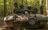 Un militaire ukrainien porte un obus d'un char T-72 de fabrication soviétique, dans la région de Soumy, près de la frontière avec la Russie, le 12 août 2024
