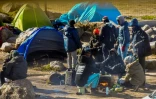 Des migrants près de leurs tentes dans un campement à la périphérie de Calais, le 8 mars 2018