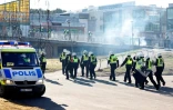 Des policiers se dirigent vers un centre commercial pendant des affrontements avec des manifestants, le 17 avril 2022 à Norrkoping, en Suède